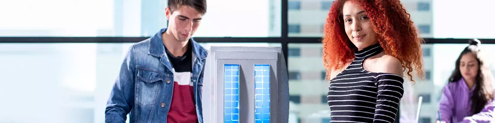 Alumnos observando la maqueta del edificio de la universidad